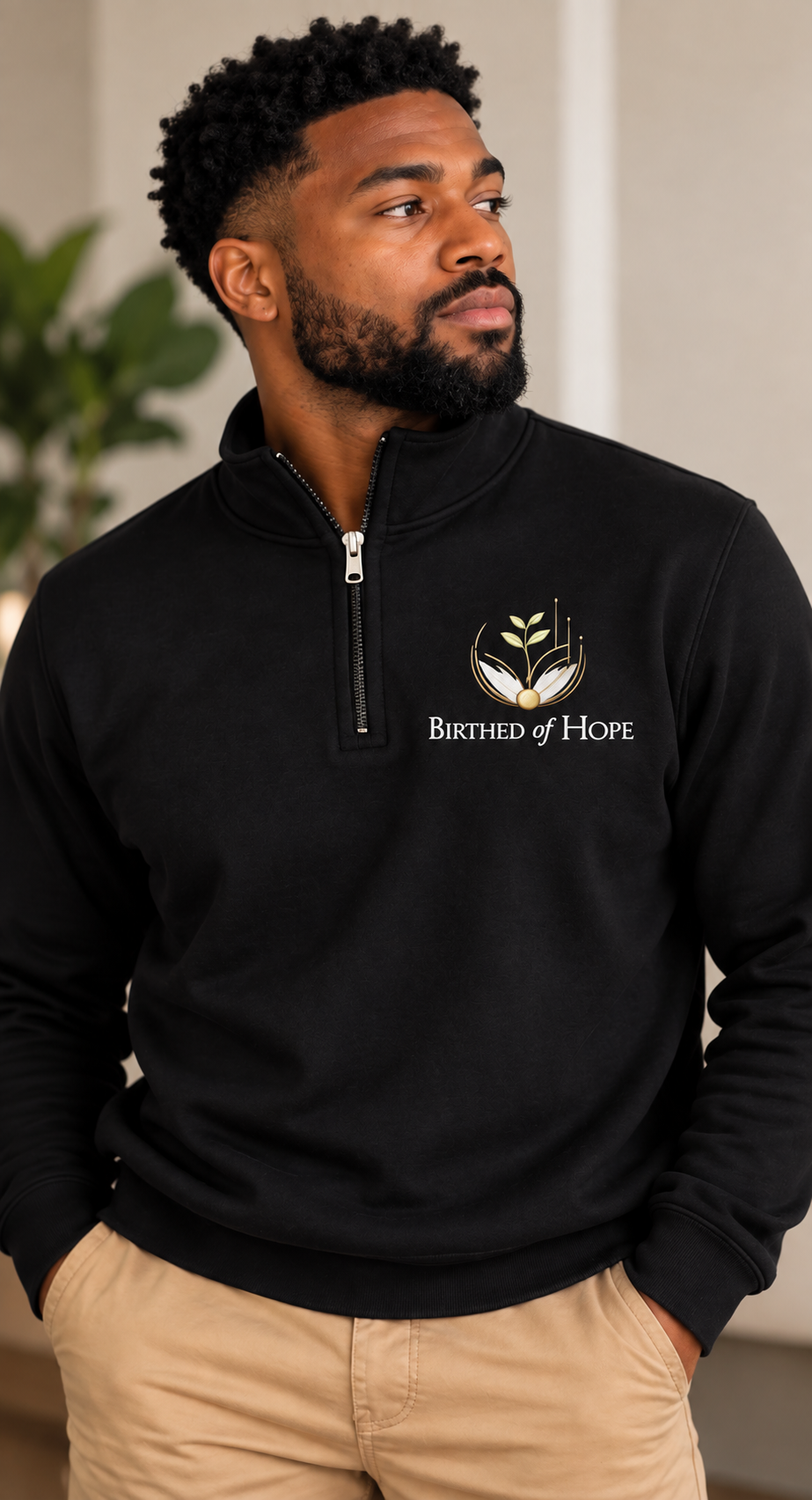 Man wearing the black Birthed of Hope quarter zip